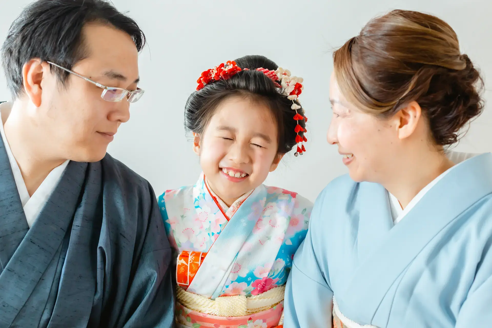 七五三の晴れ着姿の女の子を囲んで微笑む家族
