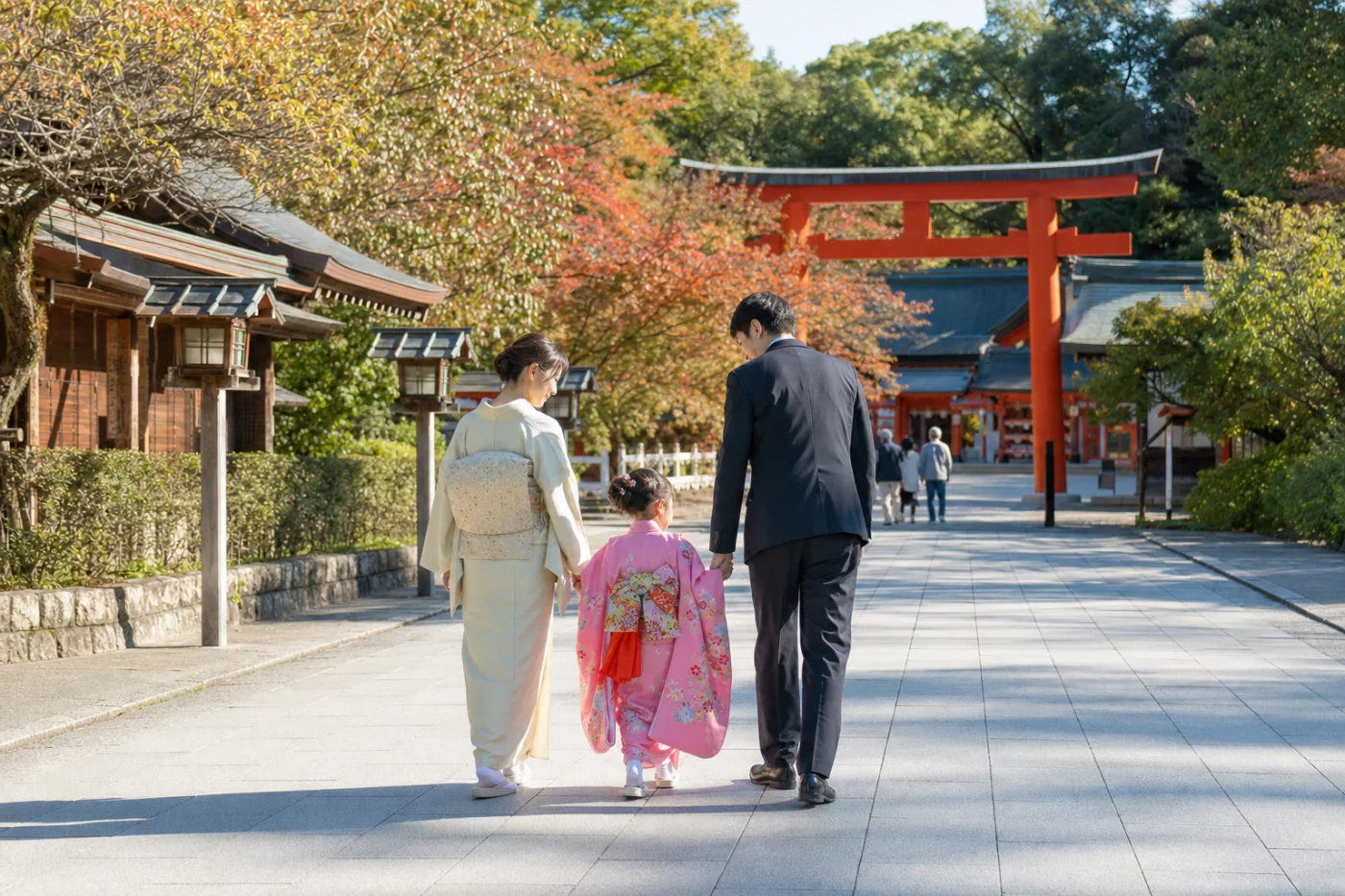 混雑の少ない秋の神社を家族で歩く様子
