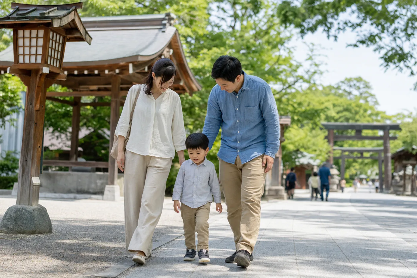 落ち着いた神社で子どもの体調を気遣いながら歩く両親